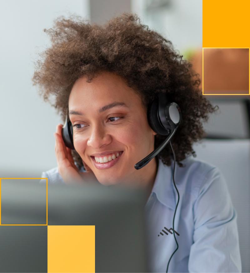 Woman wearing headset sitting in front of computer.